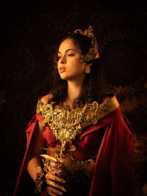 Free A striking portrait of a woman in an elaborate red and gold costume, evoking a regal and historical vibe. Stock Photo