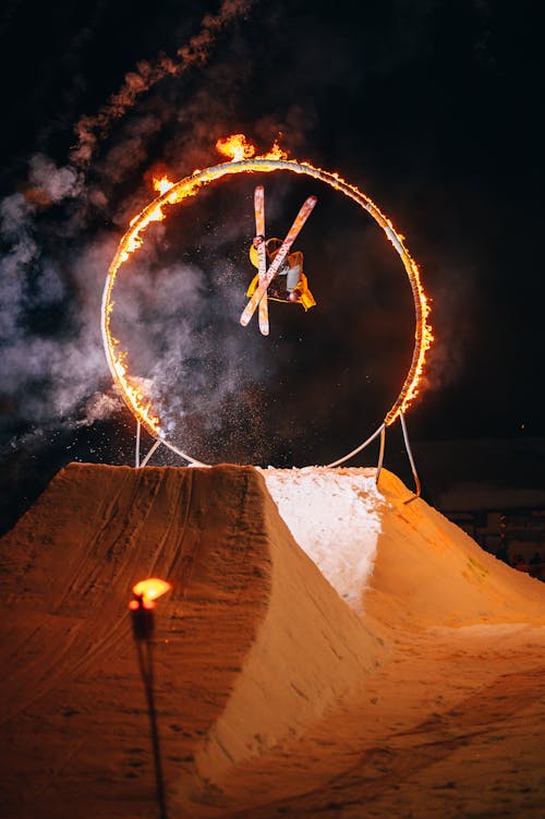 Free Man Skiing Through Fire Circle at Night Stock Photo