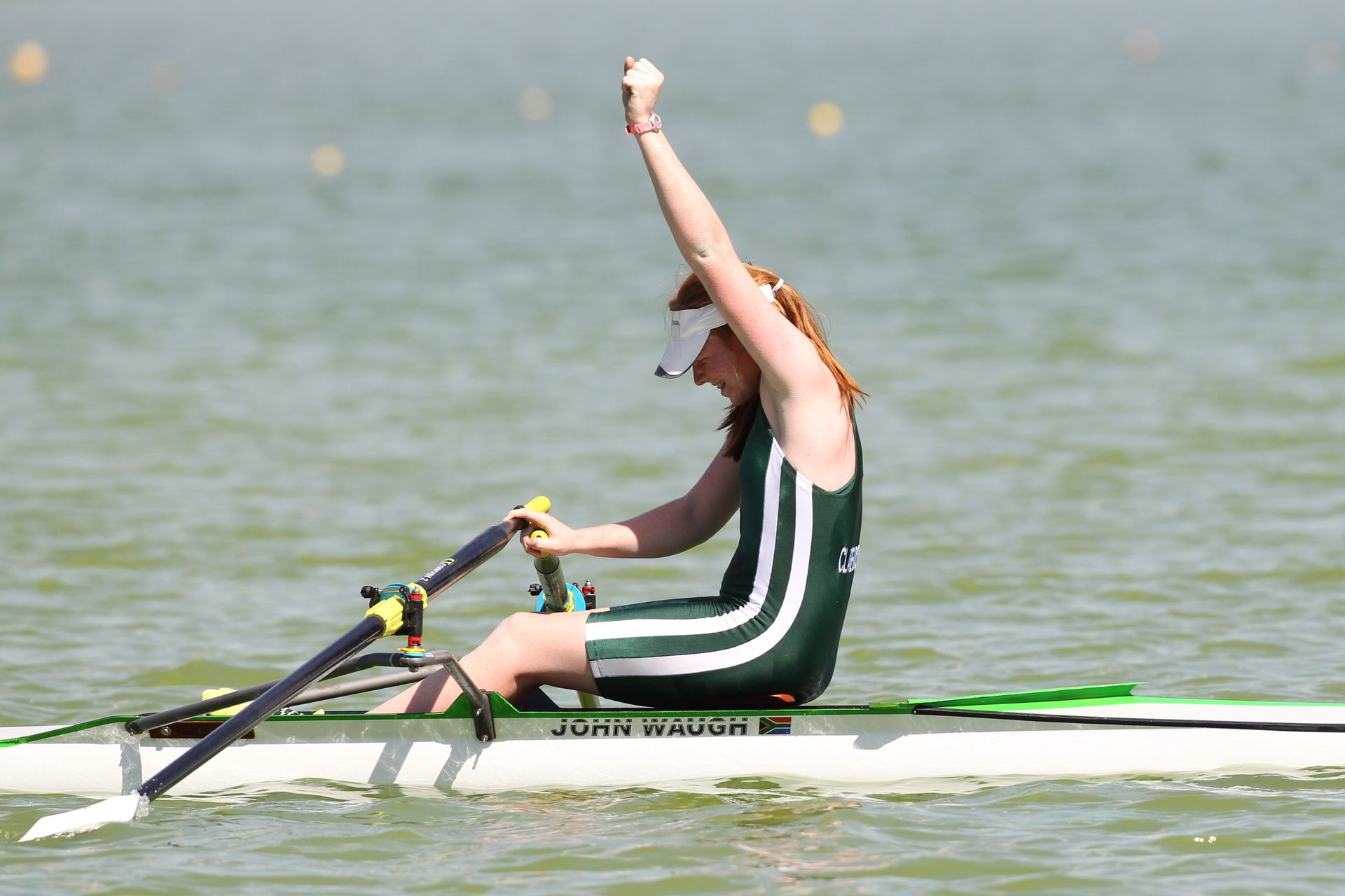 A female rower celebrates her victory in a vibrant display of enthusiasm on the water.