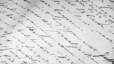 Detailed close-up of vintage cursive handwriting on old paper, elegant script.