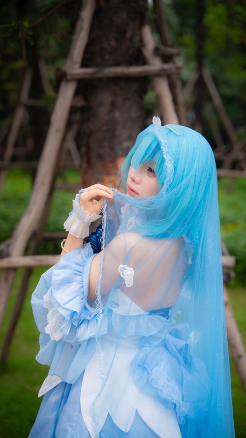 Free A person in blue fantasy cosplay attire in a lush outdoor setting, evoking an ethereal mood. Stock Photo
