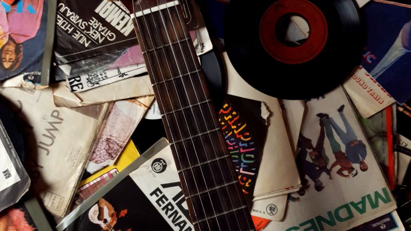 Top view of messy carton packages with music of 80s and guitar placed on top
