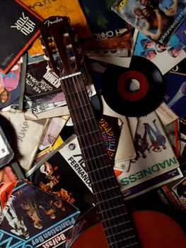 Top view of messy carton packages with music of 80s and guitar placed on top
