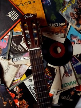A nostalgic display of a guitar amidst retro vinyl records and music albums.