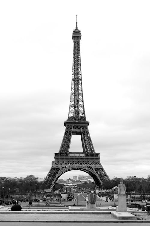 Black and white majestic famous Eiffel Tower against Elysian Fields on summer day