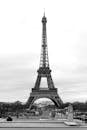 Black and white majestic famous Eiffel Tower against Elysian Fields on summer day