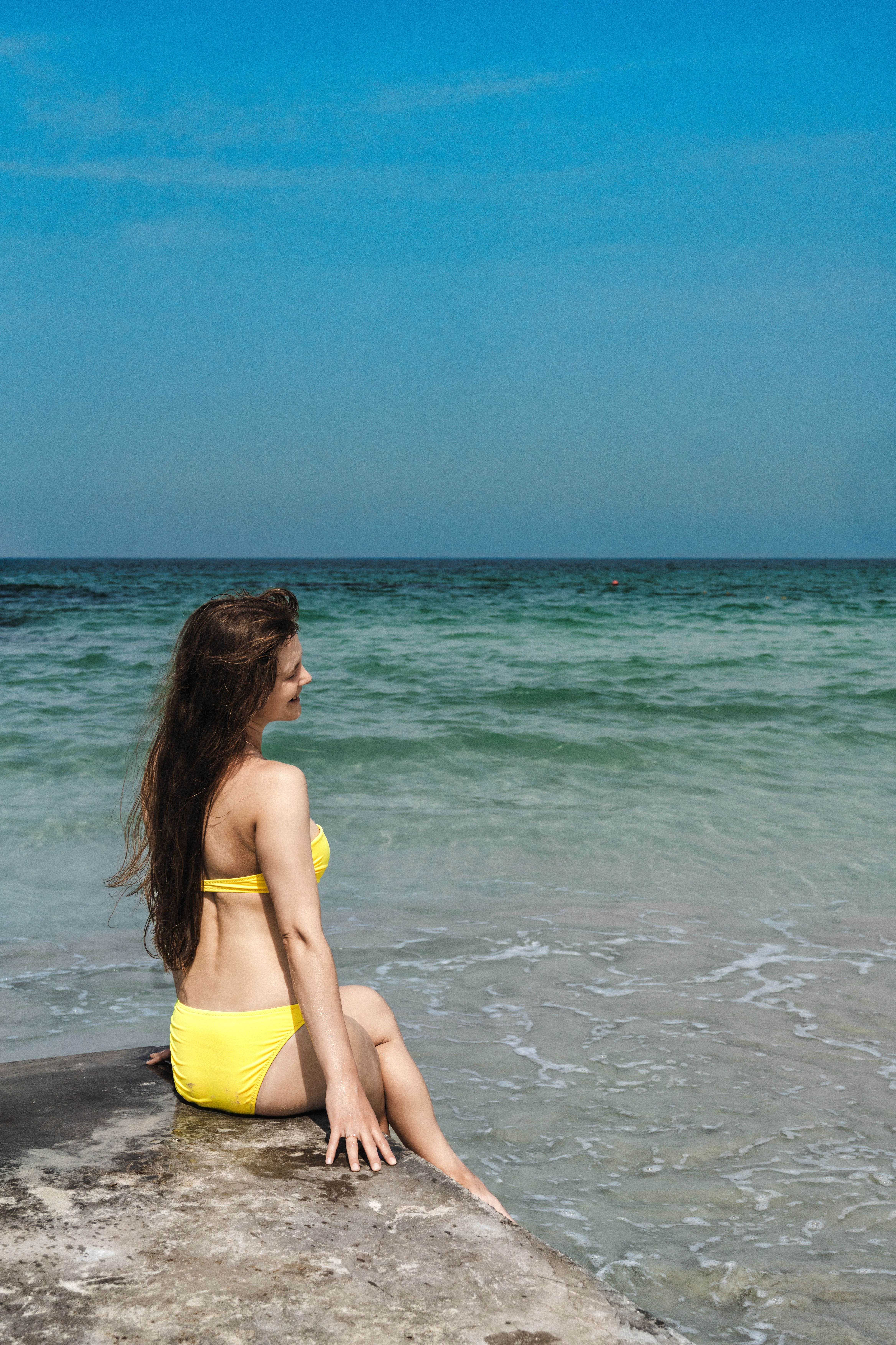 A woman enjoys a sunny day by the sea in Sharjah, UAE.