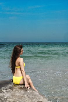 A woman enjoys a sunny day by the sea in Sharjah, UAE.
