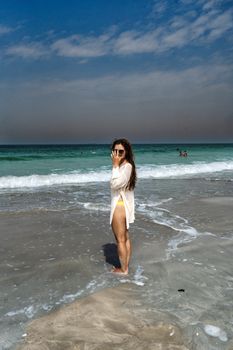 A woman enjoying a sunny day at the beach in Sharjah, United Arab Emirates. Perfect for travel and lifestyle themes.
