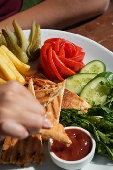 Vibrant platter showcasing pickles, tomatoes, cucumbers, toast, and sauce.