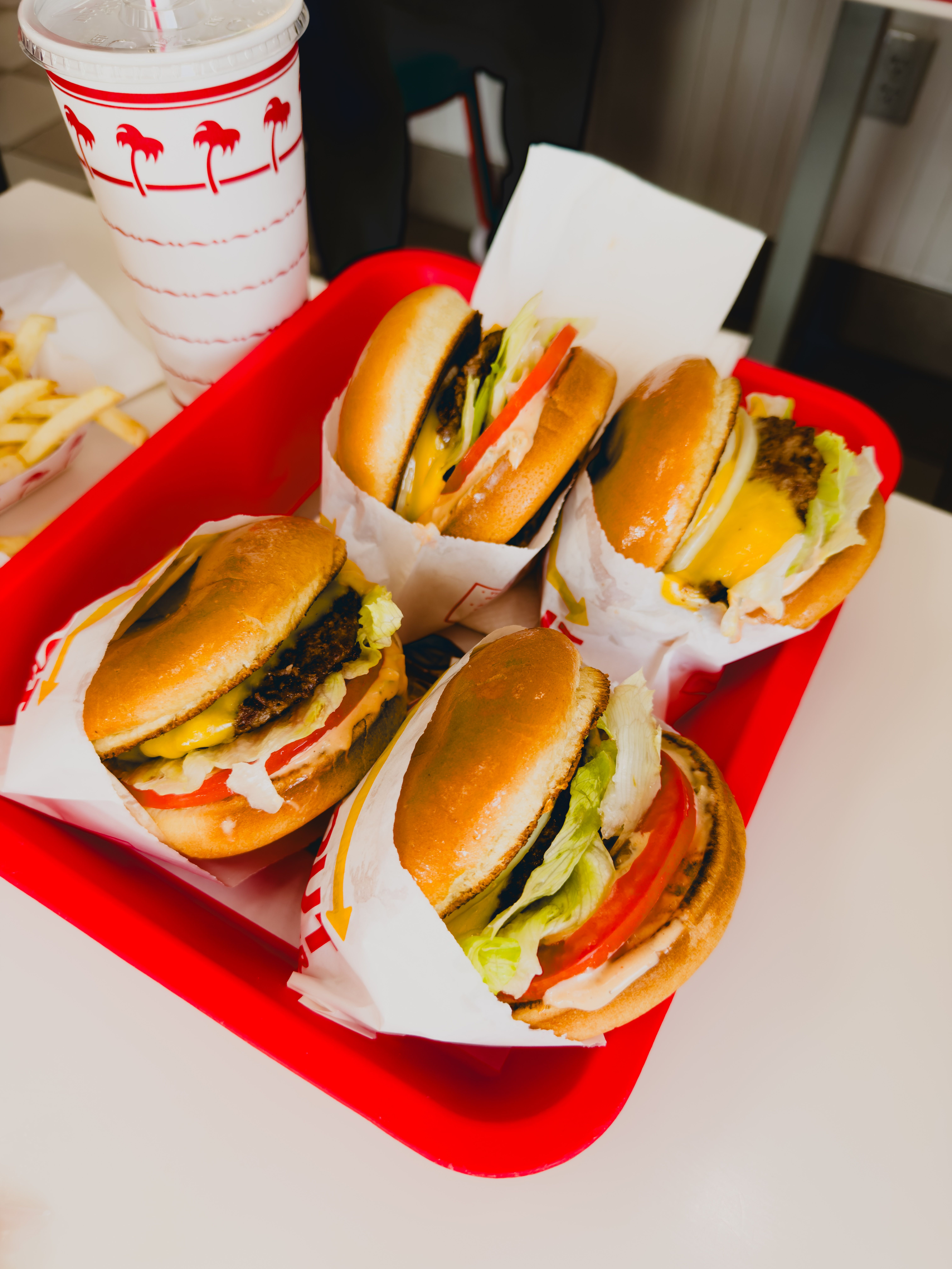 Mouthwatering cheeseburgers with fries on red tray at a classic Dallas diner.
