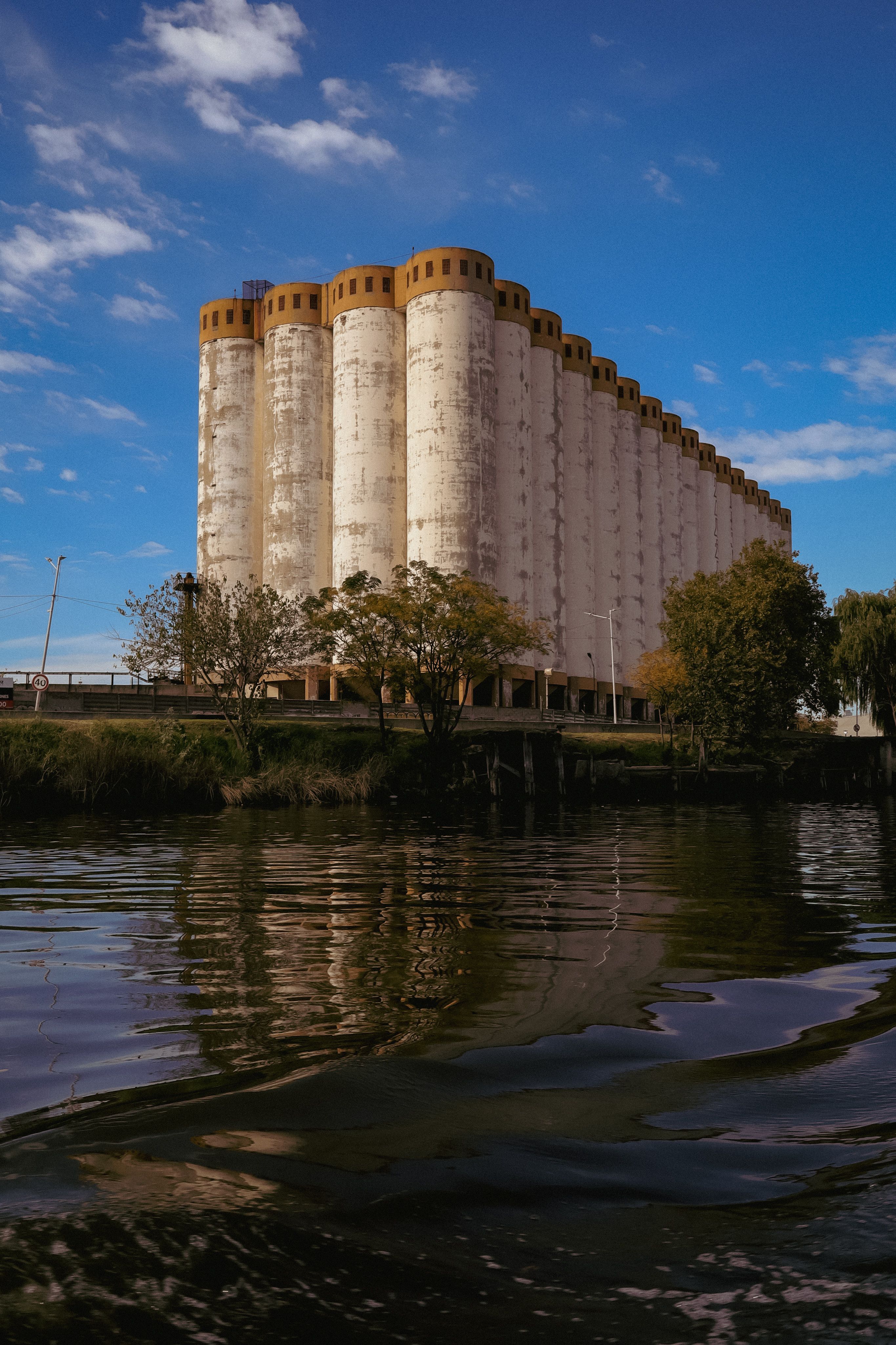 Old Concrete Grain Silos Reflecting in Water · Free Stock Photo