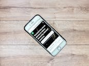 木桌上放着一部当代手机，屏幕正打开着网站