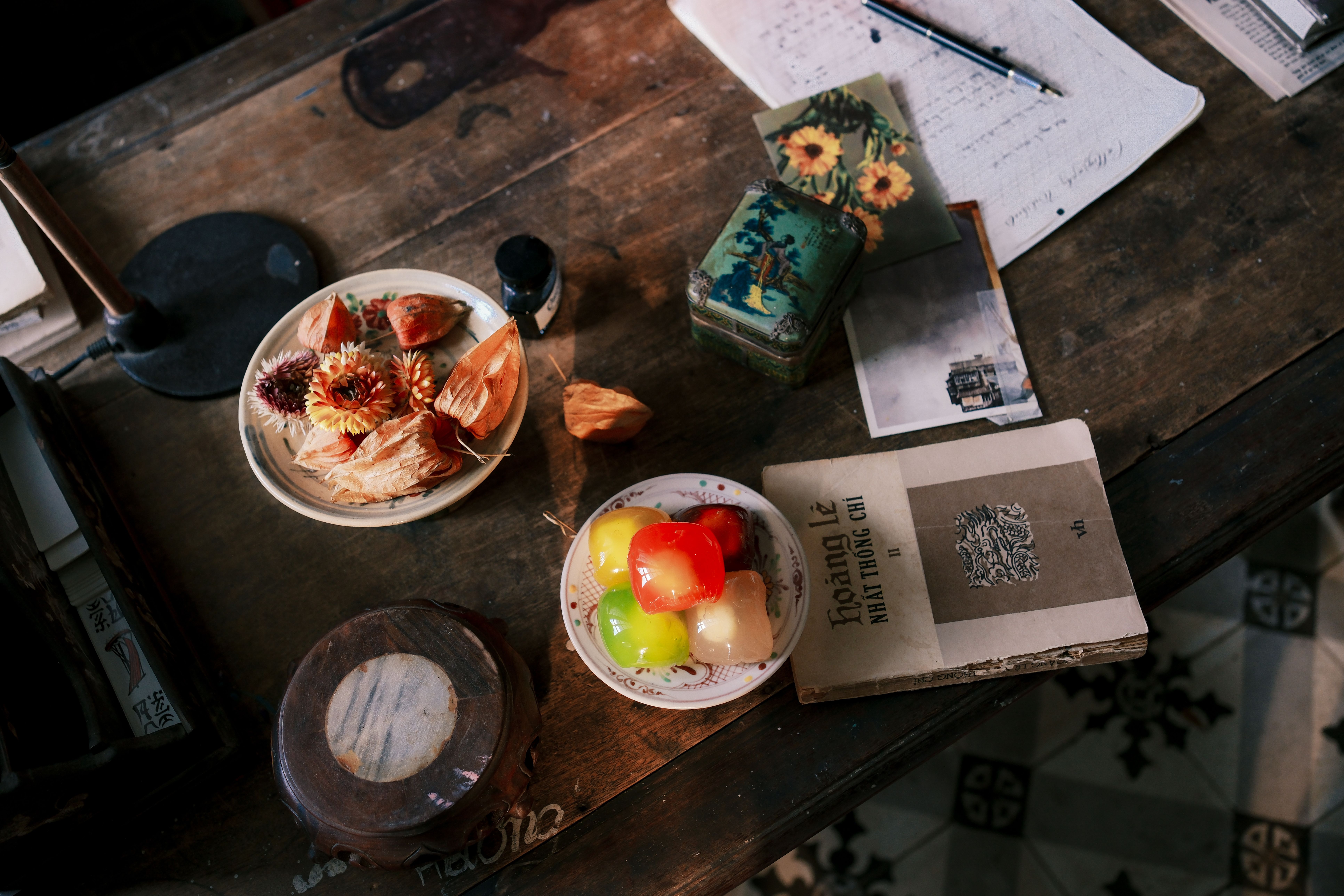 Top view of a rustic desk with vintage items, snacks, and colorful decor elements.
