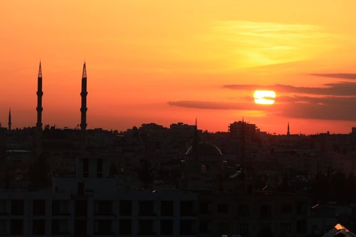 Free Stunning silhouette of city skyline with minarets at sunset, casting warm hues in the sky. Stock Photo