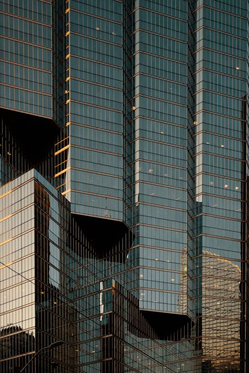Free Close-up of modern skyscraper facade with reflections, geometric patterns, and glass surfaces. Stock Photo