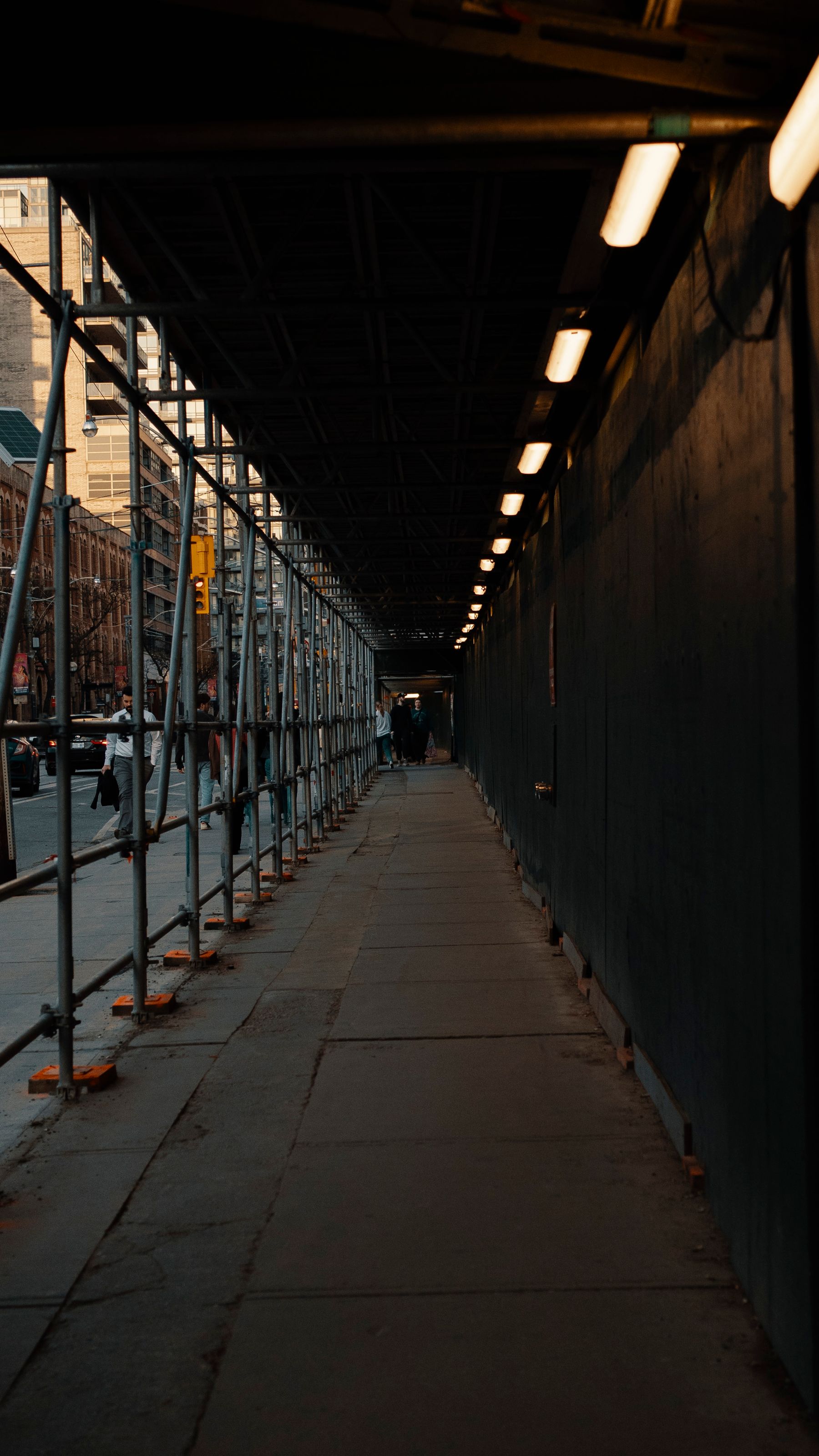 Scaffolding along an older New York City streetscape, illustrating access and staging considerations in restoration estimating.