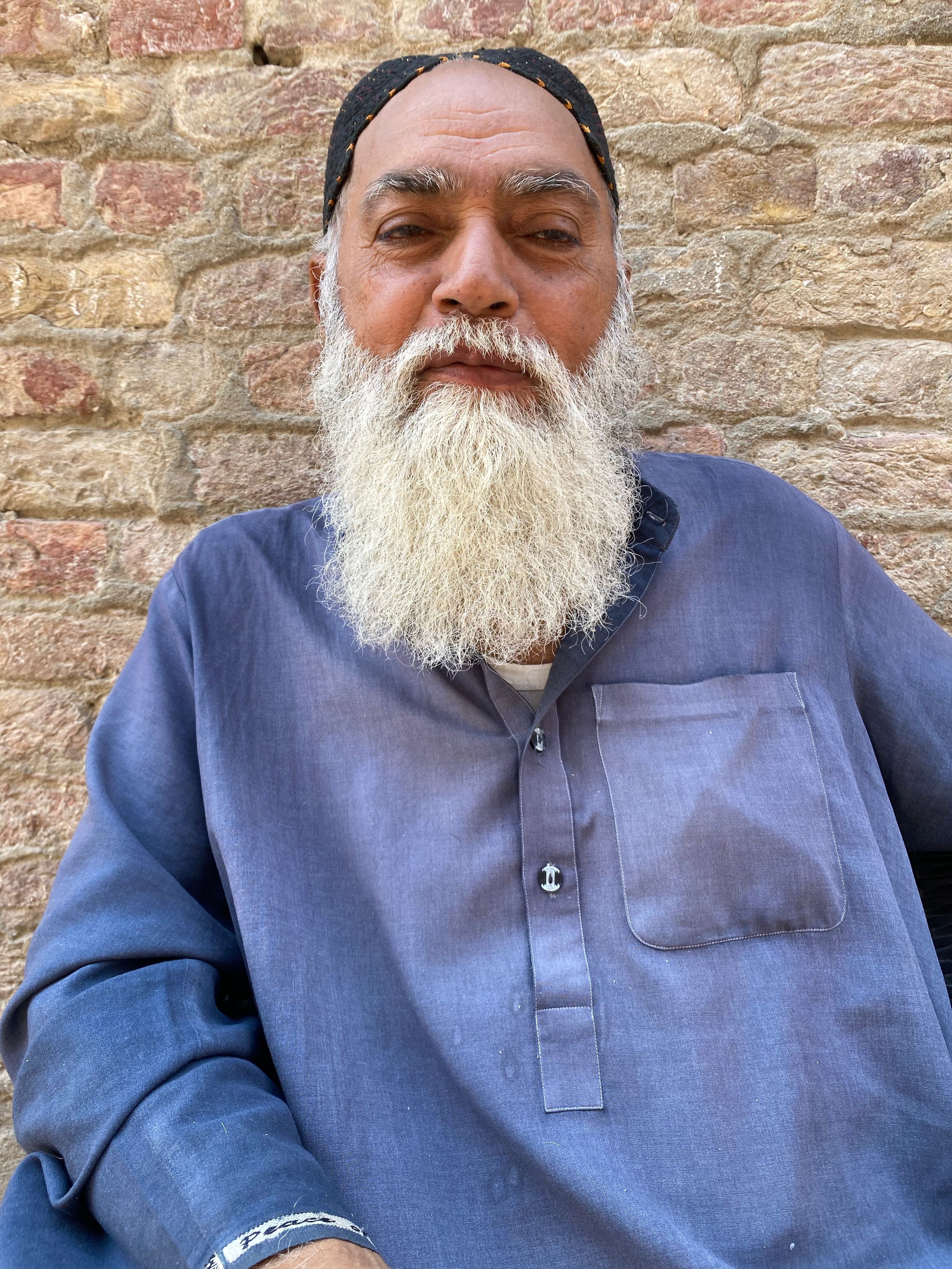 Portrait of an Elderly Man Against a Brick Wall
