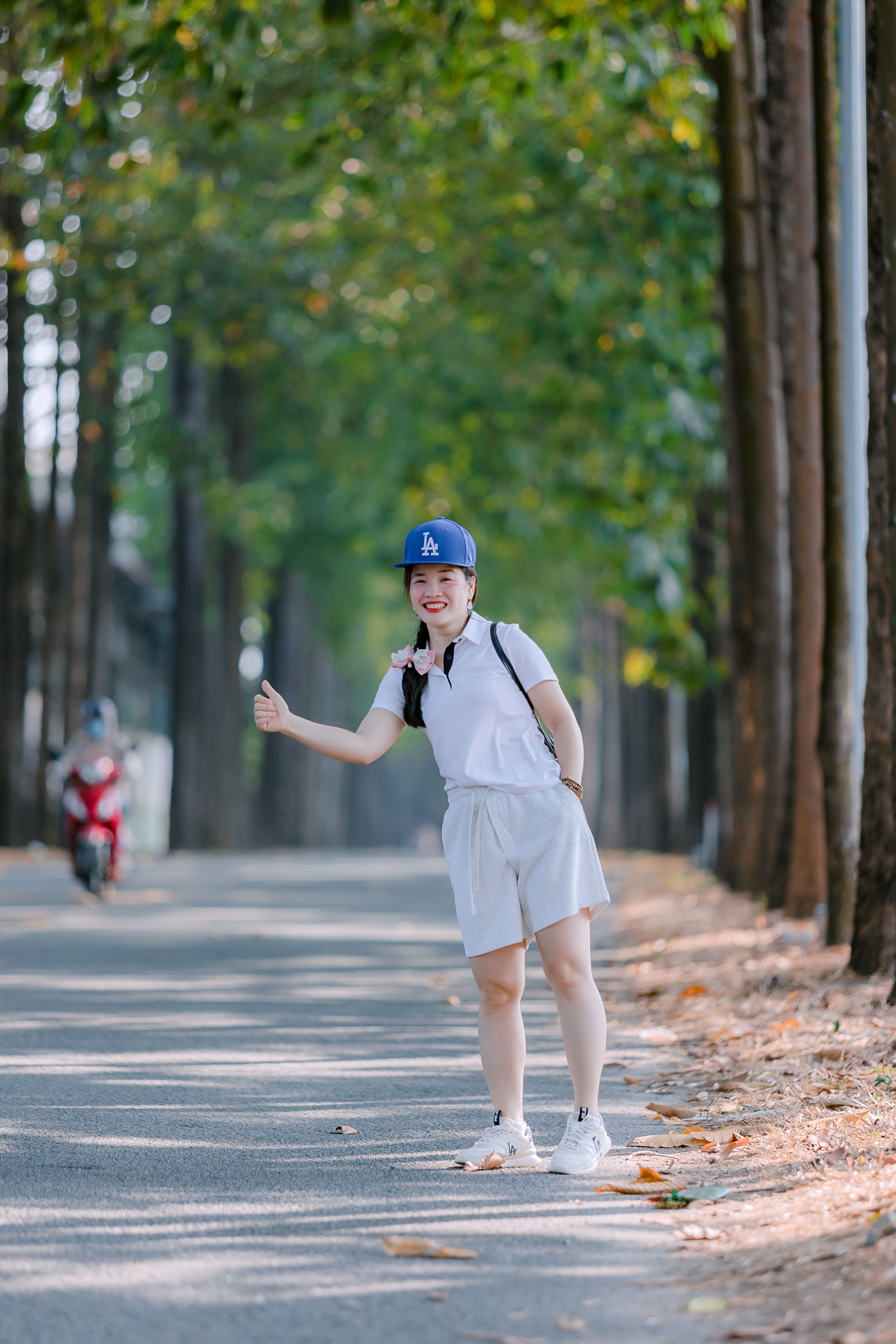 Happy Woman Hitchhiking on Forest Path