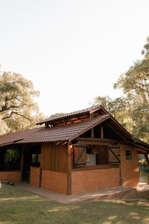 Free Charming wooden cabin with peaked roof surrounded by lush trees, ideal for outdoor retreats. Stock Photo