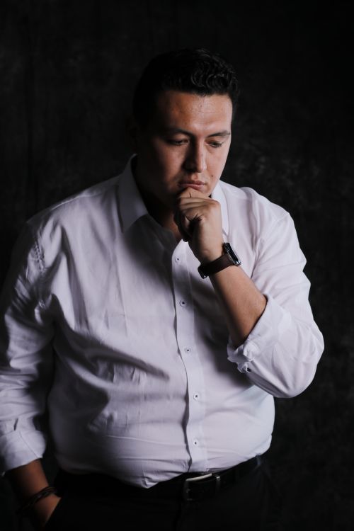 Free Man in deep thought captured in a low-key studio setting. Ideal for introspection themes. Stock Photo