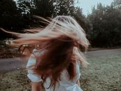 Woman with flying hair in summer park