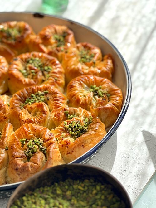 Free Delicious golden pastries topped with crushed pistachios, perfect for dessert. Stock Photo
