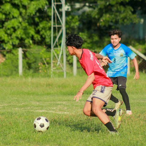 Free Two players compete in a vibrant soccer match outdoors in Myawaddy, Myanmar. Stock Photo