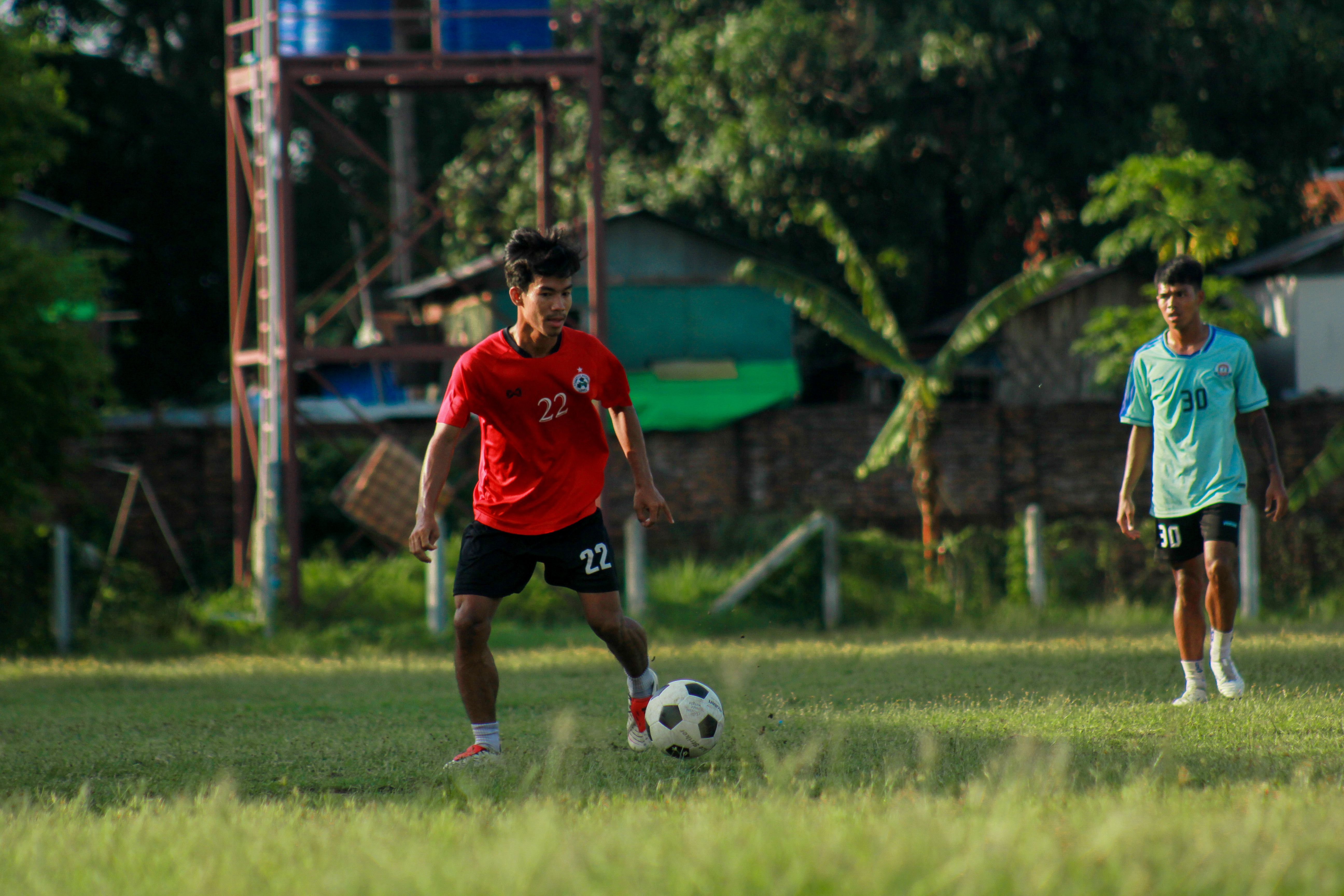 Soccer match in Myawaddy, Myanmar with young adults playing outdoors.