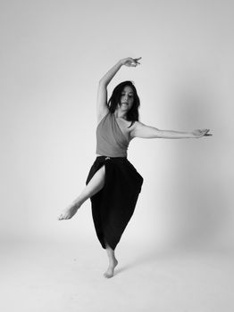 Artistic black and white photo of a dancer in an elegant pose, captured in a studio setting.