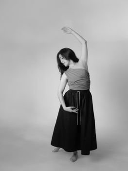 Artistic black and white photo of a woman in graceful dance pose, showcasing elegance.