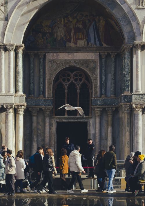 Free A busy scene of people outside a historic European cathedral, showcasing architectural details. Stock Photo