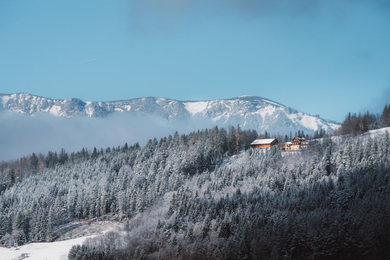 Stunning snowy landscape of Semmering Pass with cozy cabins and alpine scenery.