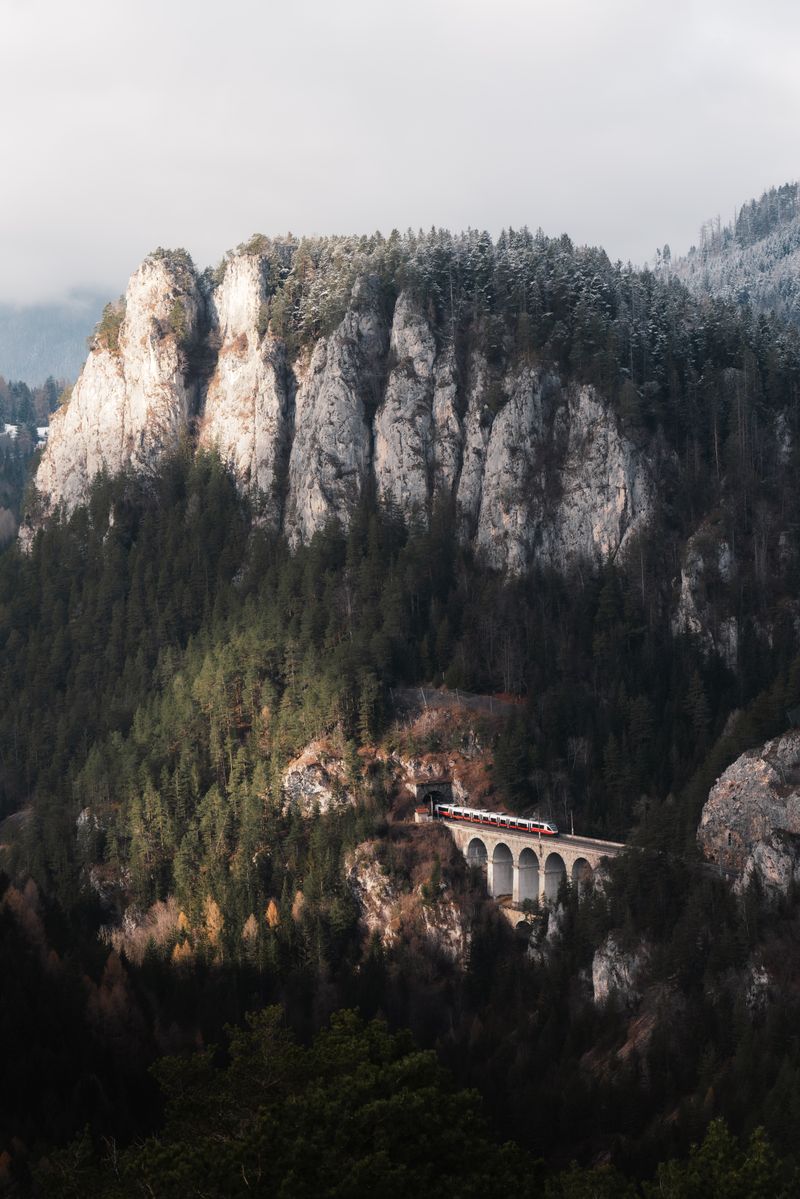 Breathtaking landscape of the Semmering Railway viaduct amidst misty Austrian Alps.