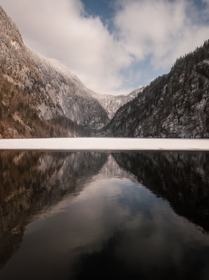 Discover the tranquil beauty of a snowy alpine lake in Styria, Austria.
