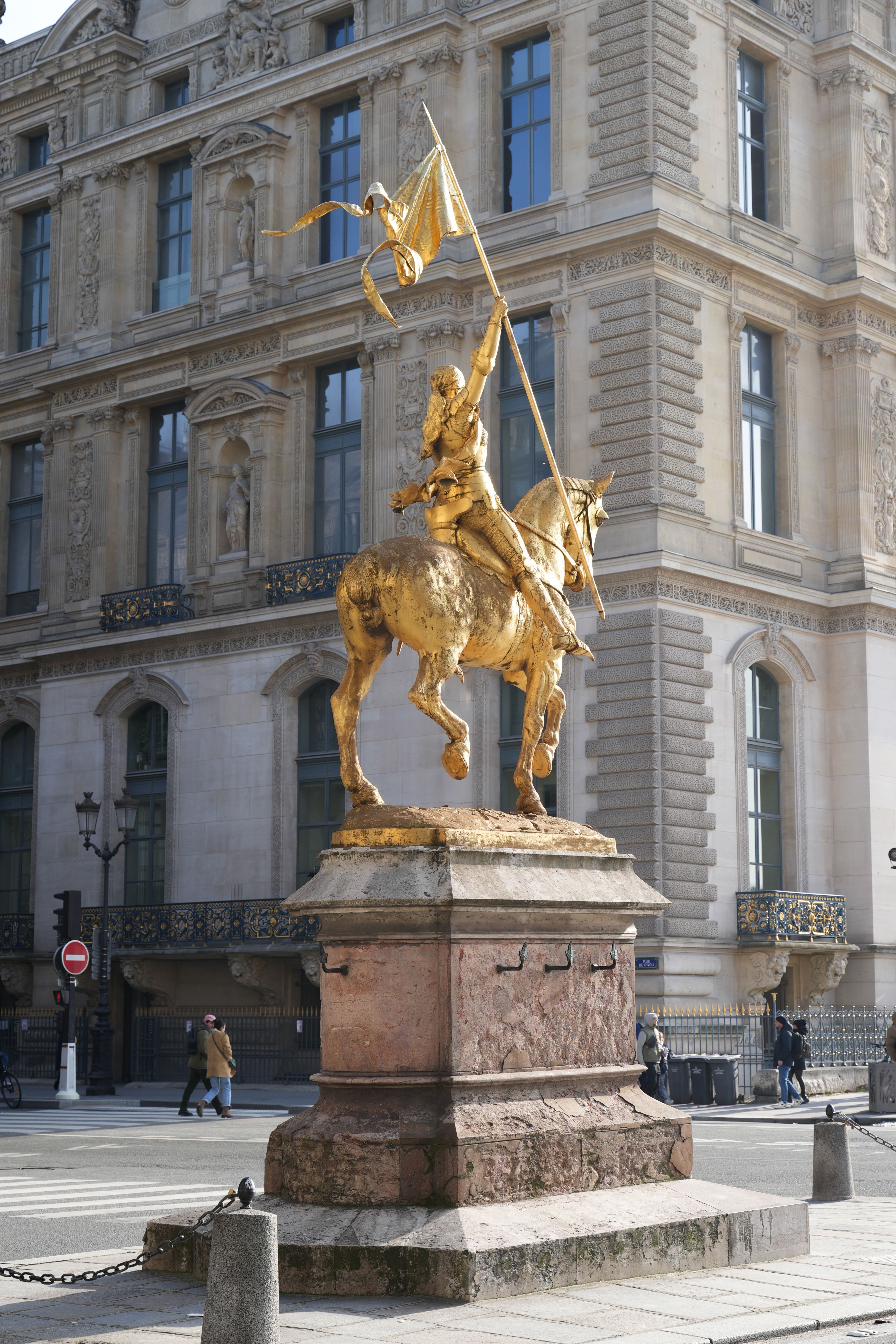 Golden equestrian statue of Joan of Arc in Paris with historical architecture background.