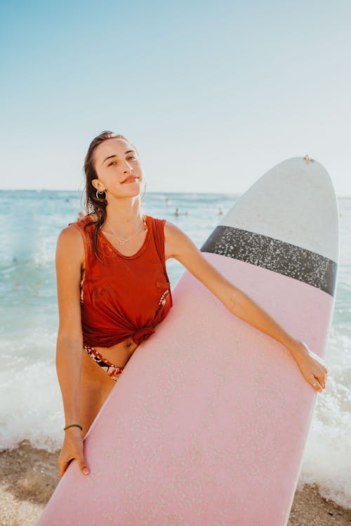 Woman In Red Tank Top Holding Surfboard