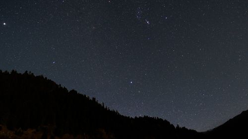 Free A breathtaking view of a star-filled night sky above silhouetted mountains, perfect for astronomy enthusiasts. Stock Photo
