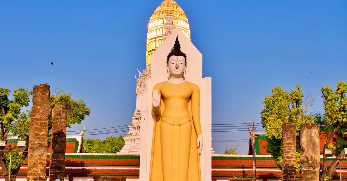 Impressive Buddha statue at Wat Phra Si Rattana Mahathat during a sunny day in Phitsanulok, Thailand.