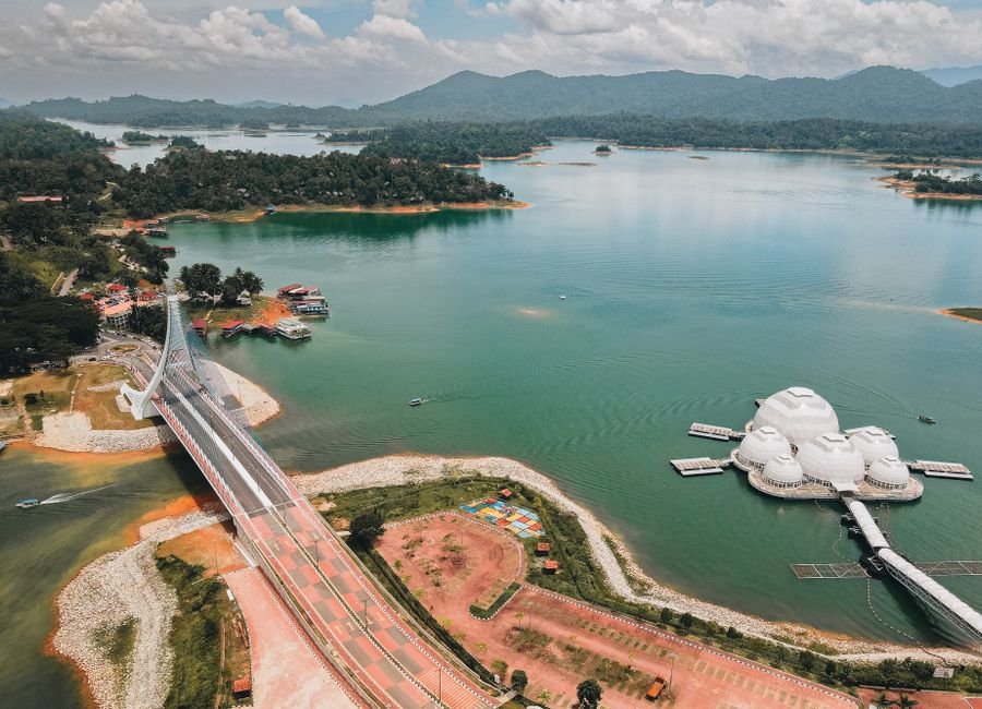 Breathtaking aerial shot of a picturesque lake with a bridge and unique floating structures.