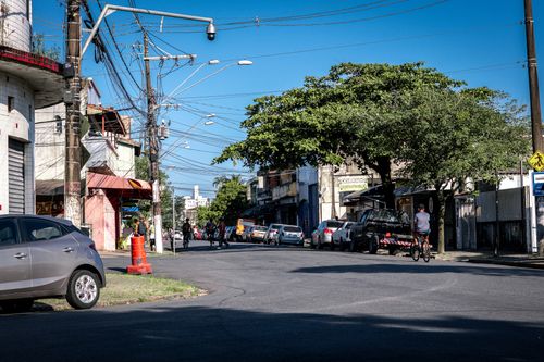 Free Vibrant urban street with cyclist, cars, and bright day atmosphere. Stock Photo