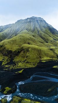 Aerial view of a lush green mountain landscape with flowing rivers on an island.