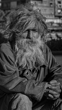 A striking black and white portrait of an elderly man with a long beard, capturing the raw expressions of street life in Beirut.