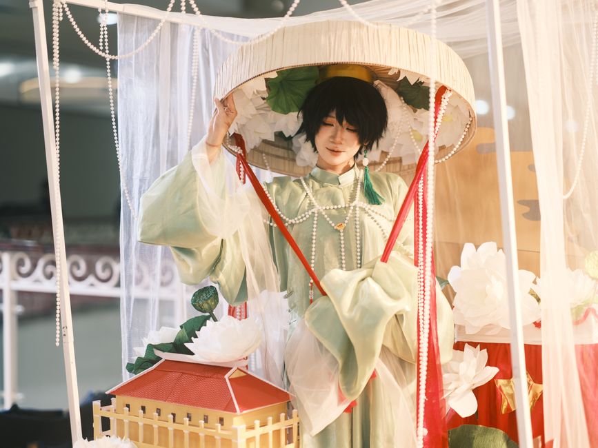 Person in traditional Vietnamese attire displayed at a cultural festival with decorative elements.