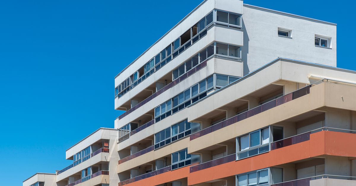 Contemporary multi-story apartment buildings with balconies under a clear blue sky, showcasing modern architecture.