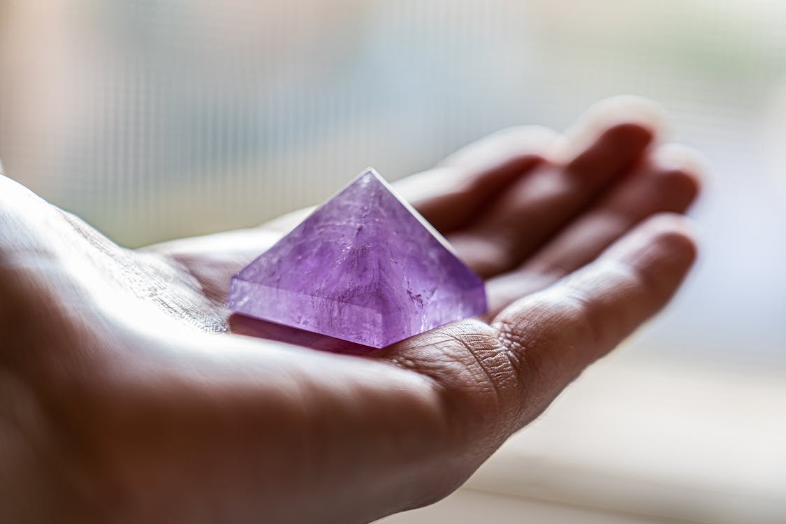 Amethyst Crystal on Person's Hand