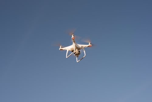 Drone Bianco Che Vola Sotto Il Cielo Blu