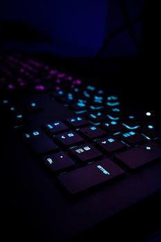 Creative close-up of a gaming keyboard with neon blue and purple lighting, perfect for tech enthusiasts.