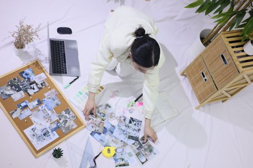 Free Overhead view of a person working in a creative space with a mood board, planner, and laptop. Stock Photo