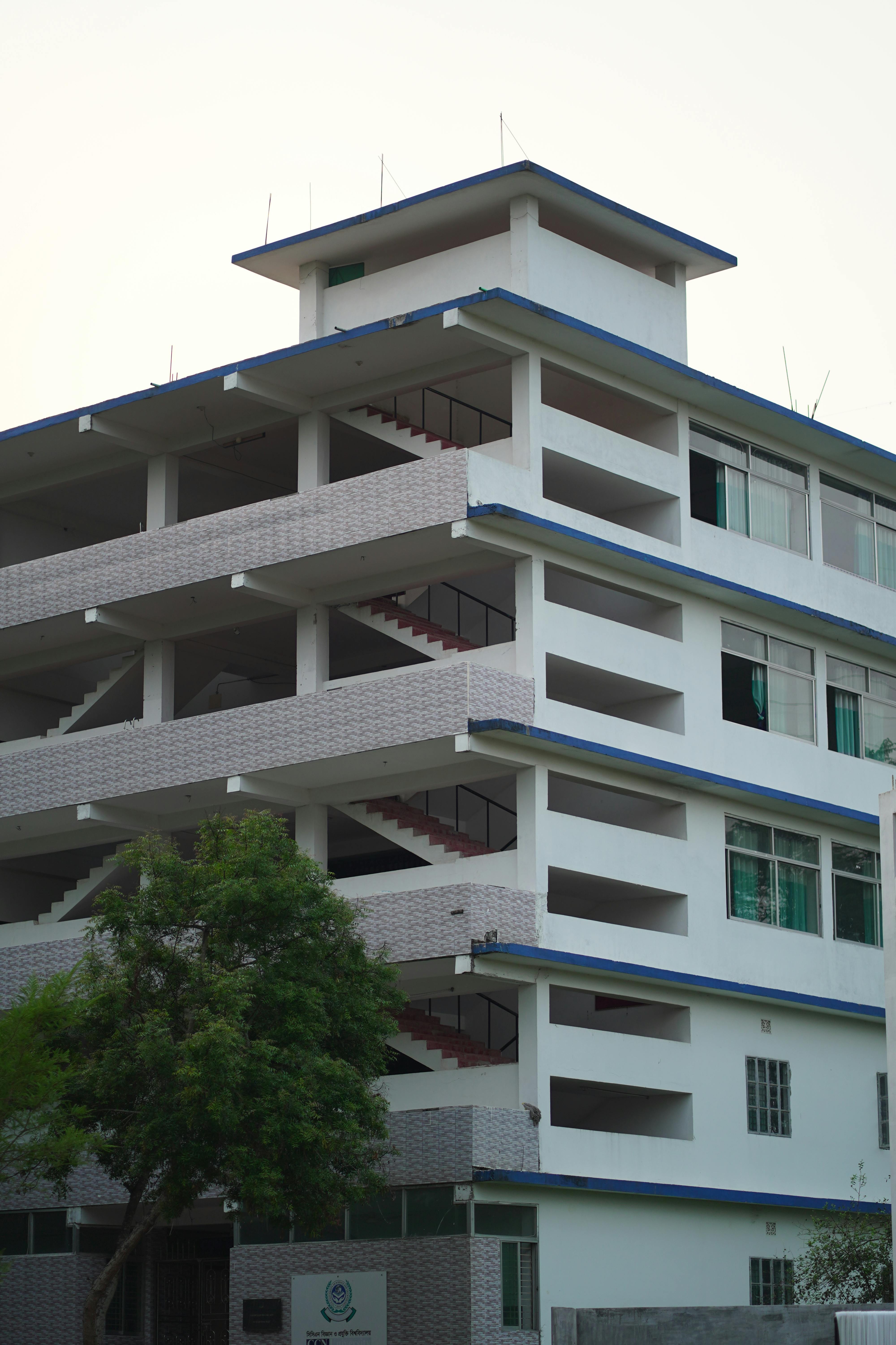 Multi-story building featuring open staircases and a minimalist architectural design.